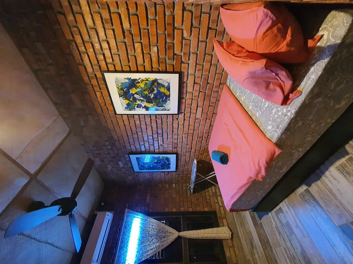 Queen bedroom with brick feature wall and ceiling fan
