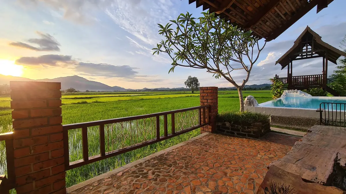 Sunrise over the padi fields from the brick terrace with wrought iron railing
