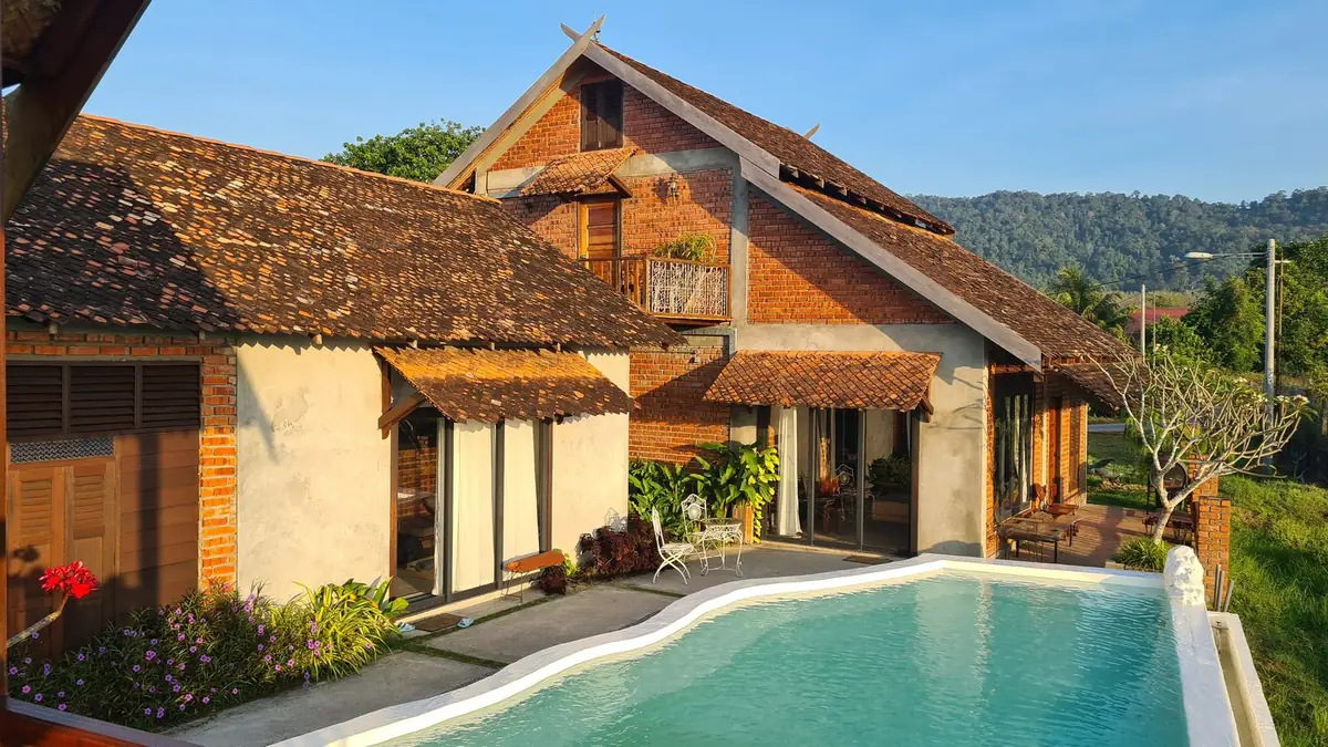 Rumah Bendang villa with singgora tiled roofs and pool in morning light