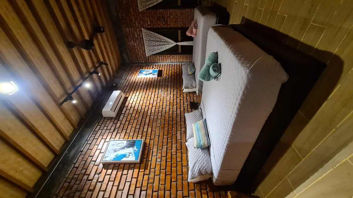 Downstairs bedroom with two queen beds against exposed brick